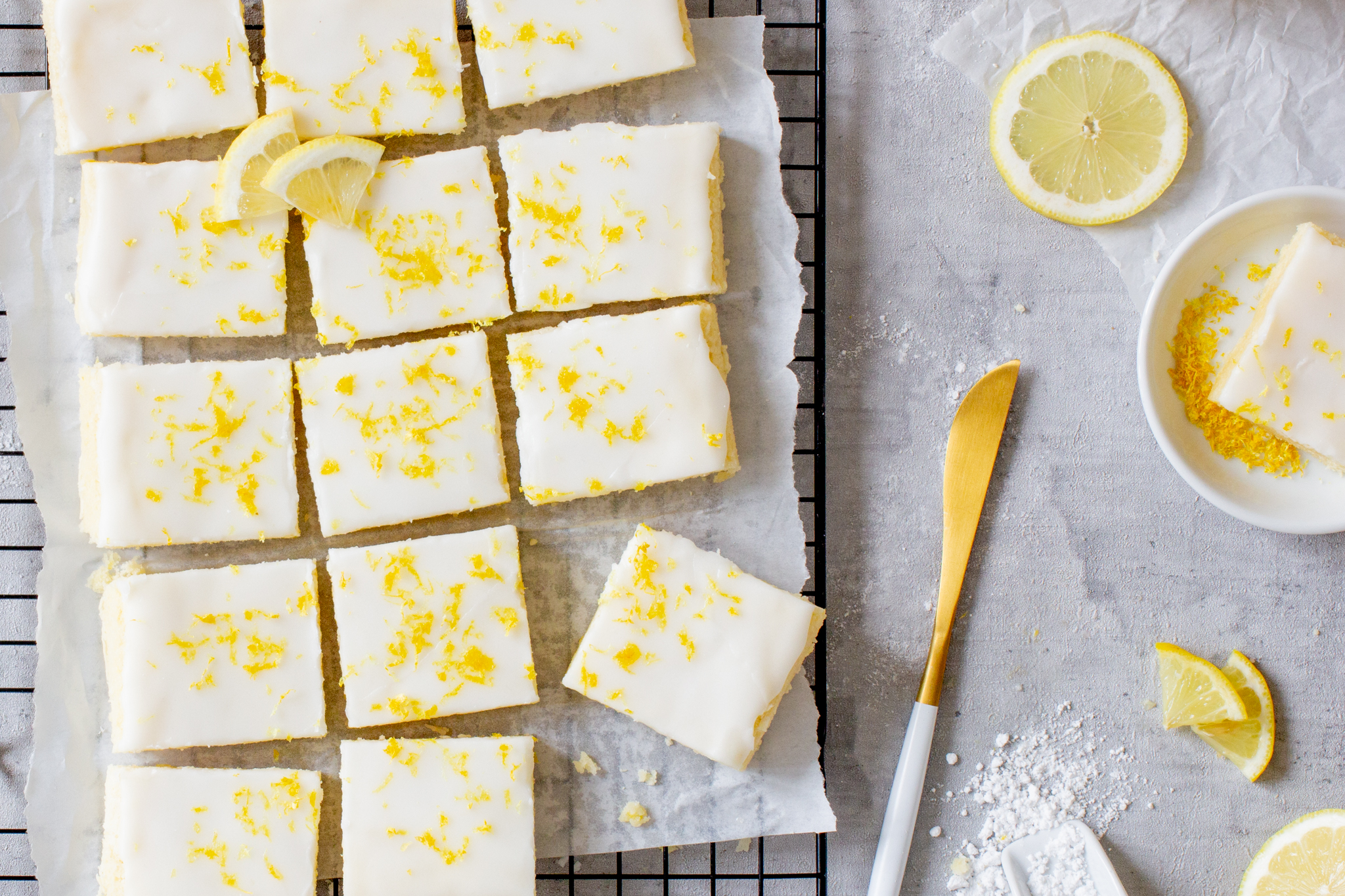Zitronen Blondies auf einem Backgitter mit Zitronenzeste garniert